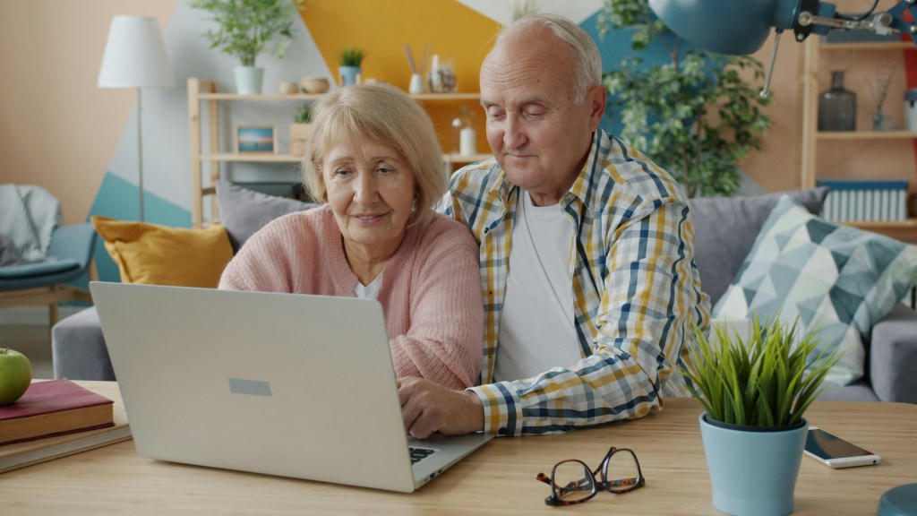 Elderly man and woman looking at a laptop
