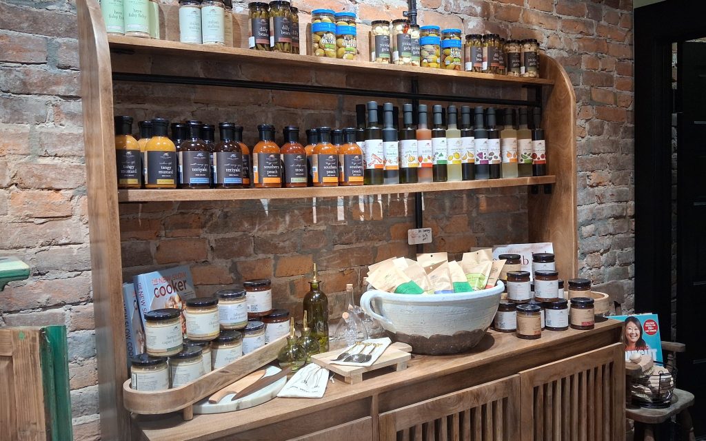 a display of bottles of sauces, vinegar,s and olives